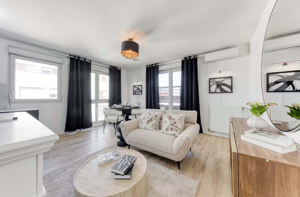 Bright living room with a cream sofa and black curtains