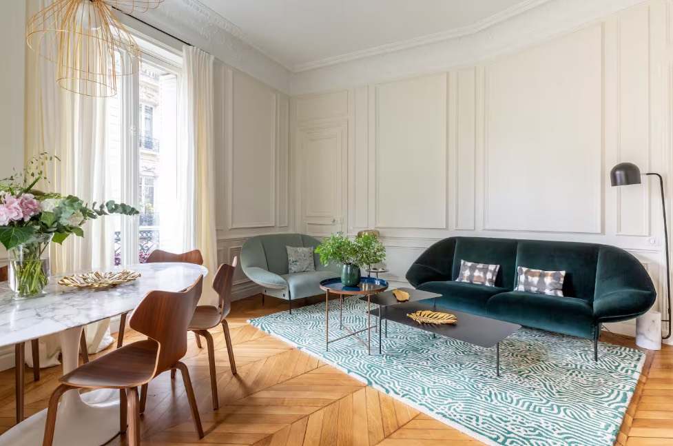 Living room with a dark teal sofa and marble dining table